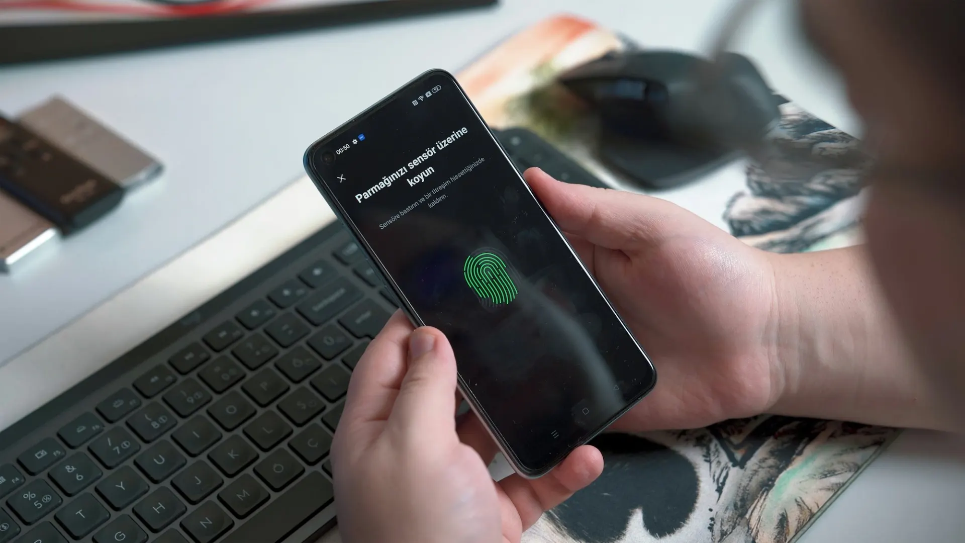 Handen houden een telefoon vast die om een vingerafdruk vraagt